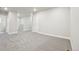 Bright carpeted hallway leads to doors and the staircase with railing at 594 Fall River Ct, Brighton, CO 80601