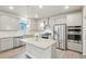 Bright kitchen features stainless appliances, granite counters, a center island and white subway tile backsplash at 594 Fall River Ct, Brighton, CO 80601