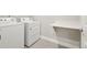 Functional laundry room with washer, dryer, and folding counter for efficient chores at 594 Fall River Ct, Brighton, CO 80601