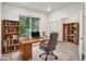 Inviting home office features a large window with natural light, built-in bookshelves, and modern desk at 594 Fall River Ct, Brighton, CO 80601