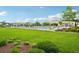 Lush green grass surrounds a community pool and lounge chairs, creating a serene oasis for residents at 594 Fall River Ct, Brighton, CO 80601