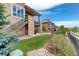 Backyard featuring a stone patio, staircase to deck, landscaping, and green lawn at 9441 Night Star Pl, Lone Tree, CO 80124