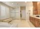 Bright bathroom features dual vanity, large walk-in shower, soaking tub, and plantation shutters for natural light and privacy at 9441 Night Star Pl, Lone Tree, CO 80124
