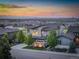 Aerial view of a modern home with a well-manicured lawn and a view of the cityscape at sunset at 9441 Night Star Pl, Lone Tree, CO 80124