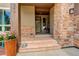 Inviting front entrance with stone accents, steps to door, and beautiful landscaping and flower pot at 9441 Night Star Pl, Lone Tree, CO 80124