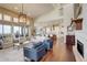 Bright living room with hardwood floors, modern furniture, fireplace, and open floor plan to kitchen at 9441 Night Star Pl, Lone Tree, CO 80124