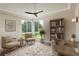 Bright home office with a large window, built-in bookshelves, and a comfortable desk at 9441 Night Star Pl, Lone Tree, CO 80124