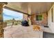 Covered stone patio with barbecue, stone pillars, and outdoor seating area with view of green space at 9441 Night Star Pl, Lone Tree, CO 80124