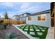 Backyard features a hot tub, pergola, artificial turf, rock landscaping, and fencing at 3844 Sandy Vista Ln, Castle Rock, CO 80104