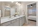 Bright bathroom features a double sink vanity with modern fixtures, quartz counters and neutral decor at 3844 Sandy Vista Ln, Castle Rock, CO 80104