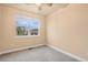 Bright bedroom features neutral carpet, ceiling fan and a large window with neighborhood view at 3844 Sandy Vista Ln, Castle Rock, CO 80104
