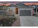 Charming home with stone accents, a two-car garage, and professional landscaping set against a colorful sky at dusk at 3844 Sandy Vista Ln, Castle Rock, CO 80104