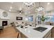 Open-concept living space featuring a kitchen island, fireplace, and stylish decor with bright, neutral tones at 3844 Sandy Vista Ln, Castle Rock, CO 80104