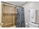 Bathroom featuring a shower-tub combination with gold door, and black-and-white shower curtain at 14208 E 1St Dr # C1, Aurora, CO 80011