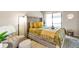 Cozy bedroom featuring a tufted headboard, bright yellow accents and natural light at 14208 E 1St Dr # C1, Aurora, CO 80011