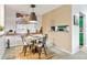 Dining area featuring a modern light fixture and artwork, with a view through a passthrough to the kitchen at 14208 E 1St Dr # C1, Aurora, CO 80011