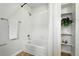 Bathroom featuring a shower-tub combo, white tiling, and built-in shelves at 2518 16Th St, Denver, CO 80211