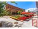 An inviting outdoor dining area with red umbrellas and chairs in a brick-paved setting at 2518 16Th St, Denver, CO 80211