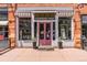 A quaint boutique storefront with striped awnings, a pink door and a stylish display window at 2518 16Th St, Denver, CO 80211