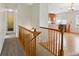 Hallway with wooden railings and carpeted floor, leading to the kitchen with hardwood floors at 11847 Trail View Ln, Parker, CO 80134
