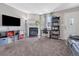 Cozy living room featuring a fireplace, large TV, neutral walls, and a dedicated desk with outside light at 17427 E Rice Cir # C, Aurora, CO 80015
