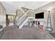 Open living room with staircase, large TV, and view to a dining room at 17427 E Rice Cir # C, Aurora, CO 80015
