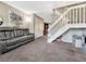 Spacious living room featuring a comfortable sofa and a staircase at 17427 E Rice Cir # C, Aurora, CO 80015