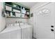 Efficient laundry room equipped with a washer, dryer, and shelving for organized storage at 757 S Wheeling St, Aurora, CO 80012
