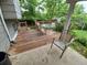 Outdoor patio with a wooden deck and dining set, surrounded by lush greenery creating a relaxing backyard space at 1962 S Ivory Way, Aurora, CO 80013