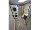 Tiled bathroom features stacked washer and dryer, stall shower with glass door, toilet, and sink at 1962 S Ivory Way, Aurora, CO 80013