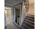 View of hallway with a small closet and stairs leading upstairs and doorway to bathroom with stacked washer and dryer at 1962 S Ivory Way, Aurora, CO 80013