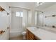 Well-lit bathroom featuring a shower over tub and a large mirror at 11642 Moline Ct, Commerce City, CO 80640