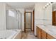 Bright bathroom featuring double sinks, a shower, and a bathtub at 11642 Moline Ct, Commerce City, CO 80640