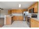 Well-lit kitchen with light wood cabinets and stainless steel appliances at 11642 Moline Ct, Commerce City, CO 80640