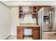 Kitchen boasts a stainless steel refrigerator, granite counters, and wooden cabinets at 10251 W 44Th Ave # 8-102, Wheat Ridge, CO 80033