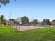 Community tennis court with fencing, parking area and a grassy area, providing space for active residents at 10251 W 44Th Ave # 8-102, Wheat Ridge, CO 80033