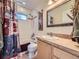 Bathroom with a tub and shower combination, a sink with a mirror, and a small window at 11526 Green Cir, Conifer, CO 80433