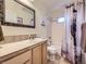 Bright bathroom featuring a decorative mirror, tiled countertops and shower/tub with neutral colored walls at 11526 Green Cir, Conifer, CO 80433