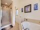 Bathroom with a bathtub, shower stall, and a view into another room with a toilet and window at 11526 Green Cir, Conifer, CO 80433