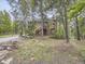 Two-story log cabin with a wooden stairway entrance is surrounded by a dense forest of mature trees at 11526 Green Cir, Conifer, CO 80433