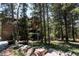 Quaint mountain home exterior showcasing natural wood, wooded lot and rock border with street sign at 11526 Green Cir, Conifer, CO 80433