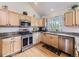 Well-lit kitchen with stainless steel appliances, wooden cabinets, and granite countertops at 11526 Green Cir, Conifer, CO 80433