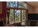 Living room featuring large windows with mountain views, comfy seating, and entertainment center at 11526 Green Cir, Conifer, CO 80433