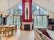 Living room featuring fireplace, soaring ceilings, large windows with views, and nearby dining table at 11526 Green Cir, Conifer, CO 80433