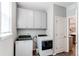 Functional laundry room featuring washer, dryer, built-in cabinets, and access to the kitchen at 20936 E 61St Ave, Aurora, CO 80019