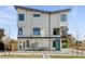 Modern three-story townhome with a light-colored facade, a unique architectural design, and a blue door at 1682 Tabor St, Lakewood, CO 80215