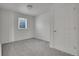 Minimalist bedroom features neutral carpet, a window, and a white door, offering a clean and simple space at 15805 W 14Th Pl, Golden, CO 80401