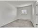 Bright bedroom features neutral carpet, white walls, and a sunlit window with outdoor views at 15805 W 14Th Pl, Golden, CO 80401