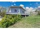 Exterior view from the side of the blue house with deck and green foliage at 15805 W 14Th Pl, Golden, CO 80401