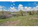 A charming single-story home is surrounded by lush greenery and mature trees under a beautiful blue sky at 15805 W 14Th Pl, Golden, CO 80401